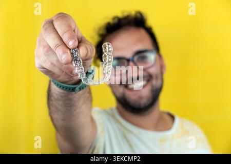 Man holding clear aligners for teeth straightening Stock Photo