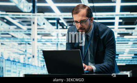 Augmented reality simulation, laptop and engineer in data center managing IT infrastructure used for database storage. Monitoring rigs, VFX compositing and man in cloud computing server farm, camera B Stock Photo