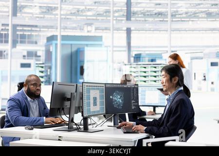 Analyzing microchip architecture layouts, AI and senior technician in RD office minimizing defects. Examining semiconductors components, artificial intelligence and Asian man fixing bottlenecks Stock Photo