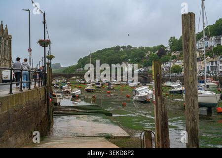 Looe Bridge viewed across the harbour with fishing boats in Looe Cornwall Stock Photo