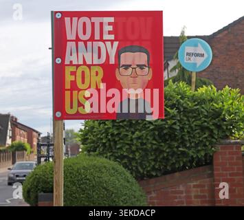Labour Vote Andy For Us poster with Reform UK sign in an Ashton-in-Makerfield front garden during the Makerfield by-election. Stock Photo