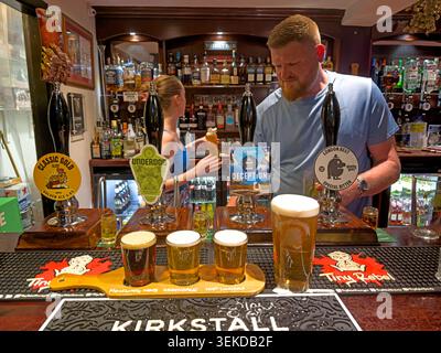 ATVH real ale bar pulling pints behind a traditional British pub counter, UK. Stock Photo