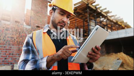 Civil engineer, online and man with tablet at construction site, scroll or project update on website. Outdoor, architect and person with tech for Stock Photo