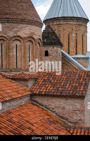 Close-up of traditional orange clay tile roofs and ancient stone church domes in Georgia Stock Photo