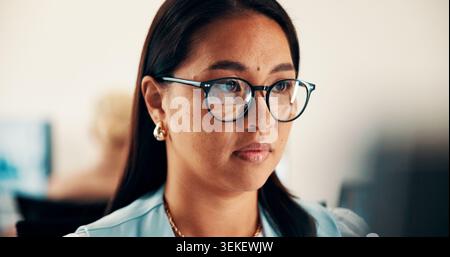 Glasses, reading and businesswoman in office with research for finance report with budget planning. Serious, thinking and Asian female financial Stock Photo