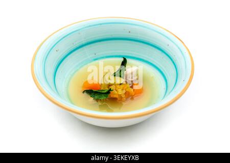 Traditional Turkish seafood soup with vegetables in elegant bowl isolated on white background Stock Photo