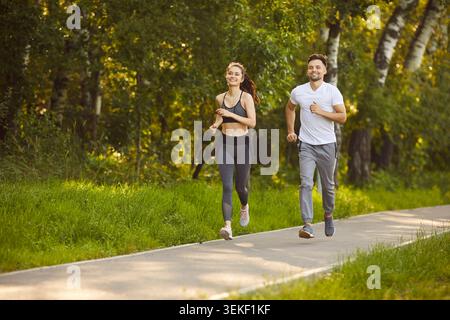 Sporty athletic jogging together in park, enjoying outdoor run and staying fit and active Stock Photo