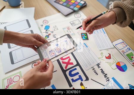 Women designers using transparent phone for AR mobile app UI UX prototyping Stock Photo
