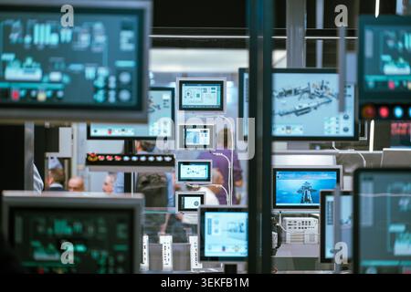 Multiple industrial control panel screens and human-machine interface (HMI) displays show monitoring software data during an automation technology tra Stock Photo