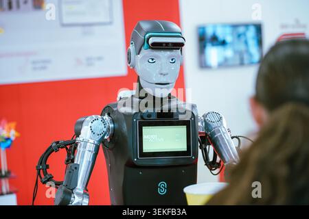 An advanced humanoid robot during a public demonstration at an industrial technology exhibition. Stock Photo