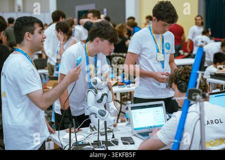 A team of students programs and tests a small Nao humanoid robot during an educational robotics competition. Stock Photo