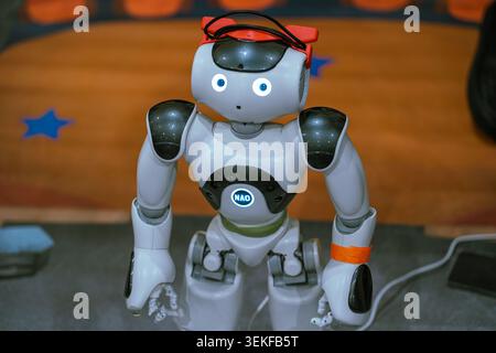 A team of students programs and tests a small Nao humanoid robot during an educational robotics competition. Stock Photo