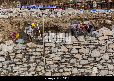 SIGUNIANGSHAN, CHINA  - NOVEMBER 4, 2019: Workers building a wall in Siguniangshan town in Sichuan province, China Stock Photo
