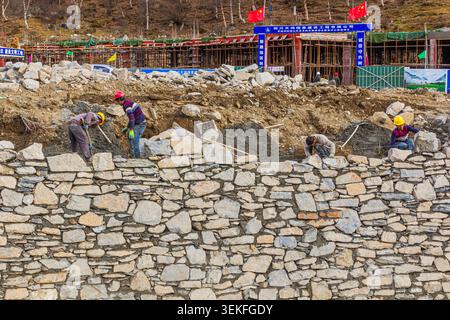 SIGUNIANGSHAN, CHINA  - NOVEMBER 4, 2019: Workers building a wall in Siguniangshan town in Sichuan province, China Stock Photo