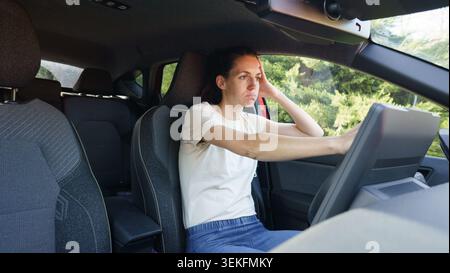 Woman feeling stressed and frustrated while sitting in her car experiencing a headache Stock Photo
