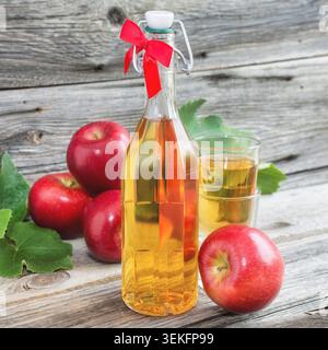 Homemade apple juice in a bottle made with red apples and vine leaves Stock Photo