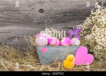 Easter decorations, pink Easter eggs in a flower box with Easterchick and heart Stock Photo