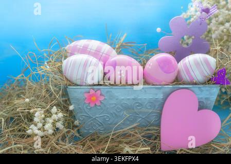Easter decorations, pink Easter eggs in a flower box with Easterchick, blossoms and heart Stock Photo