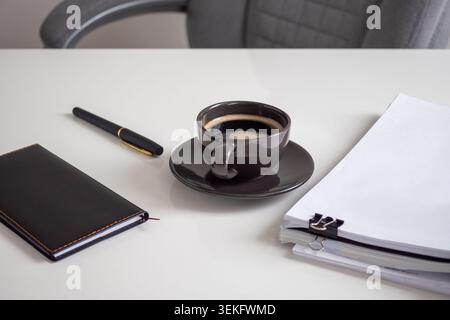 Minimalist workspace with coffee, pen, and notebook Stock Photo