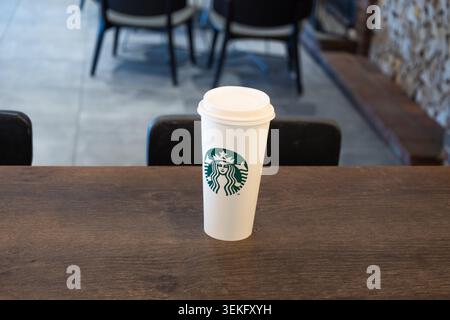 Starbucks coffee cup on a wooden table in a modern cafe interior. London, UK, 3 July 2024 Stock Photo