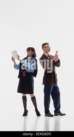 Business pair working on devices in white studio. Stock Photo