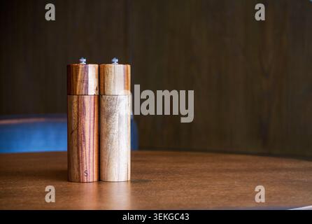 Pair of Traditional Wooden Salt and Pepper Shakers on a Restaurant Table Stock Photo