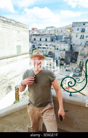 Casual middle-aged man posing in a historic old town, showcasing travel lifestyle, sightseeing, and authentic Mediterranean tourism Stock Photo