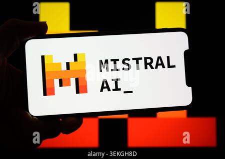 Paris, France - May 29, 2026 : A hand holds a smartphone displaying the Mistral AI logo against a yellow background. Stock Photo