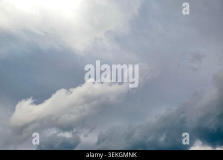Gray-blue storm clouds filling the sky, soft light, layered cloud texture, wide angle view, moody atmosphere, ample copy space Stock Photo
