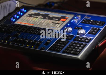 Professional stage lighting console and mixing board control panel featuring faders, knobs and touchscreen interface used in live production, theater Stock Photo
