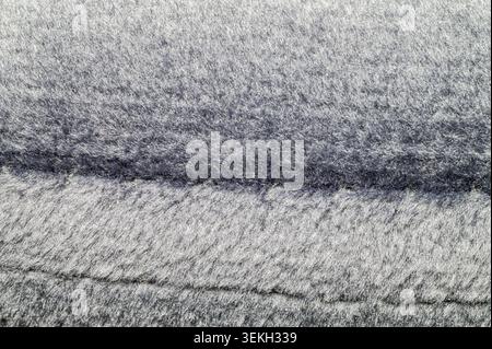 Close-up texture of a soft, fluffy grey fabric with a subtle sheen Stock Photo