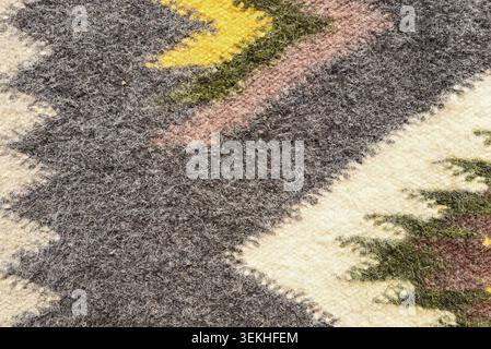 Wool fabric texture with traditional ethnic ornament and soft felt surface. Rustic textile background with geometric pattern and natural fibers. Stock Photo