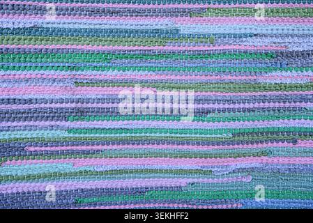 Handmade woven textile with multicolored striped pattern and soft fabric texture. Cozy textile background suitable for boho branding, creative and coz Stock Photo