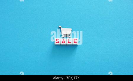 Sale blocks with shopping cart on blue background for retail promotion. Stock Photo