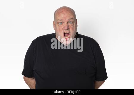 Senior Man Screaming at Camera in Black T Shirt Isolated on White Background. Stock Photo