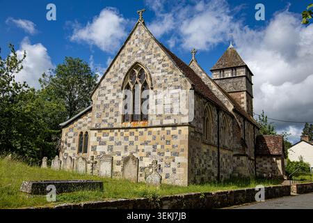 Historic stone church with a checkered flint and limestone exterior walls and an old cemetery in a sunny rural setting St Catherine's Netherhampton Stock Photo