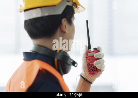 Civil engineer construction leader holding and using walkie-talkie on construction site Stock Photo
