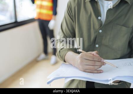 Construction engineer with architect team working check building construction progress at construction site Stock Photo