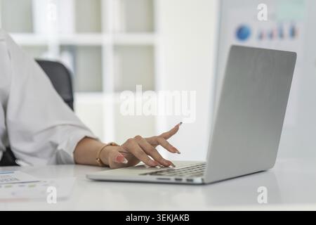 Closeup shot of hands using laptop and typing on keyboard, searching information Stock Photo