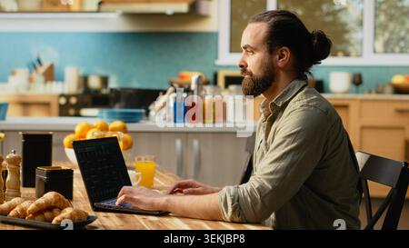Man focused on programming and software development tasks. Laptop screen displays code, scripts and binary data, illustrating system maintenance and remote work in a high-tech occupation. Stock Photo