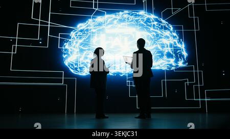 Implementing AI guardrails, devices and engineering team limiting risk of digital autonomous agent. Brainstorming, artificial intelligence safety and teamworking colleagues in tech startup, camera A Stock Photo