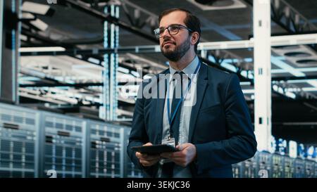 Upgrading systems, tablet and software developer in data center using augmented reality to install server racks. Monitoring server hub, VFX overlay and employee using device automation app, camera B Stock Photo