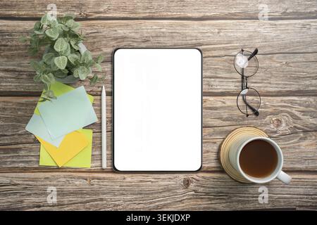 A clean workspace featuring a tablet, colorful sticky notes, a coffee cup, and glasses, ideal for remote work and organization Stock Photo