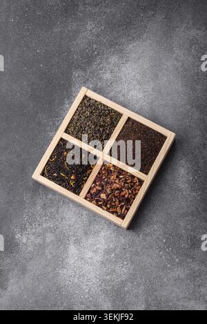 A box of various dry teas, black, green, herbal, and fruit, with flavored additives. A set of different tea varieties as a backdrop for your design Stock Photo