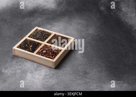 A box of various dry teas, black, green, herbal, and fruit, with flavored additives. A set of different tea varieties as a backdrop for your design Stock Photo