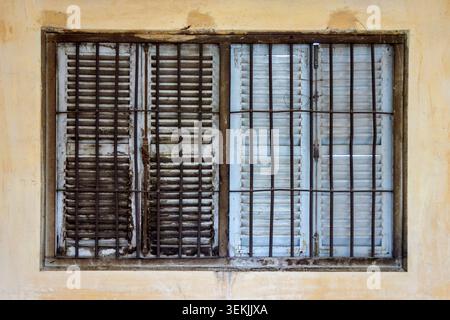Weathered Shuttered Window with Security Bars in Cambodia Stock Photo