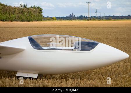 White Glider Cockpit in Harvested Cambridge Field with Ely Cathedral on Horizon Stock Photo
