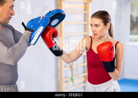Adult man and young woman practicing boxing Stock Photo