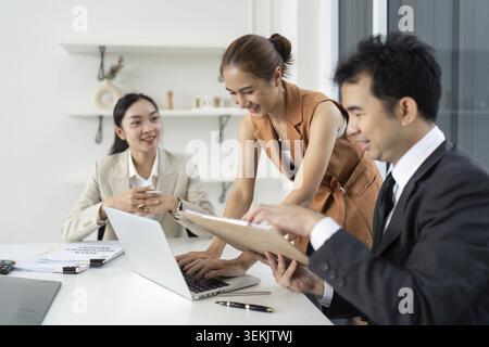 A diverse group of professionals engages in a collaborative meeting, discussing ideas and strategies in a bright office environment Stock Photo