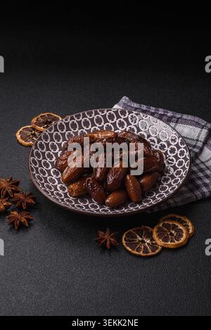 Dried dates on a ceramic plate for Ramadan or Iftar. Dried dates as a food background for your design Stock Photo